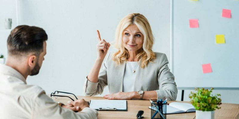 selective-focus-of-happy-recruiter-gesturing-near-employee-in-office.jpg